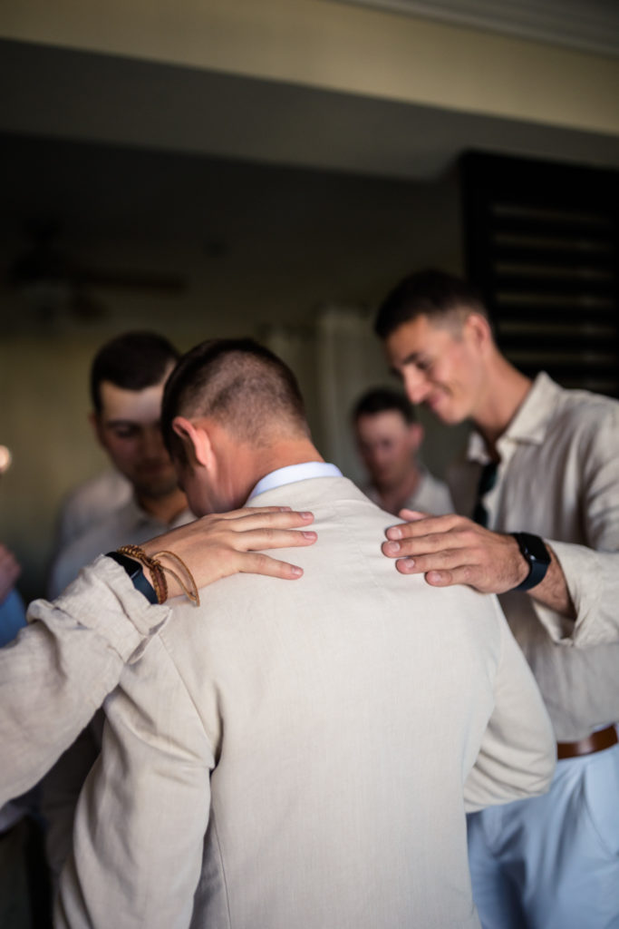 groomsmen praying while getting ready for a wedding ceremony