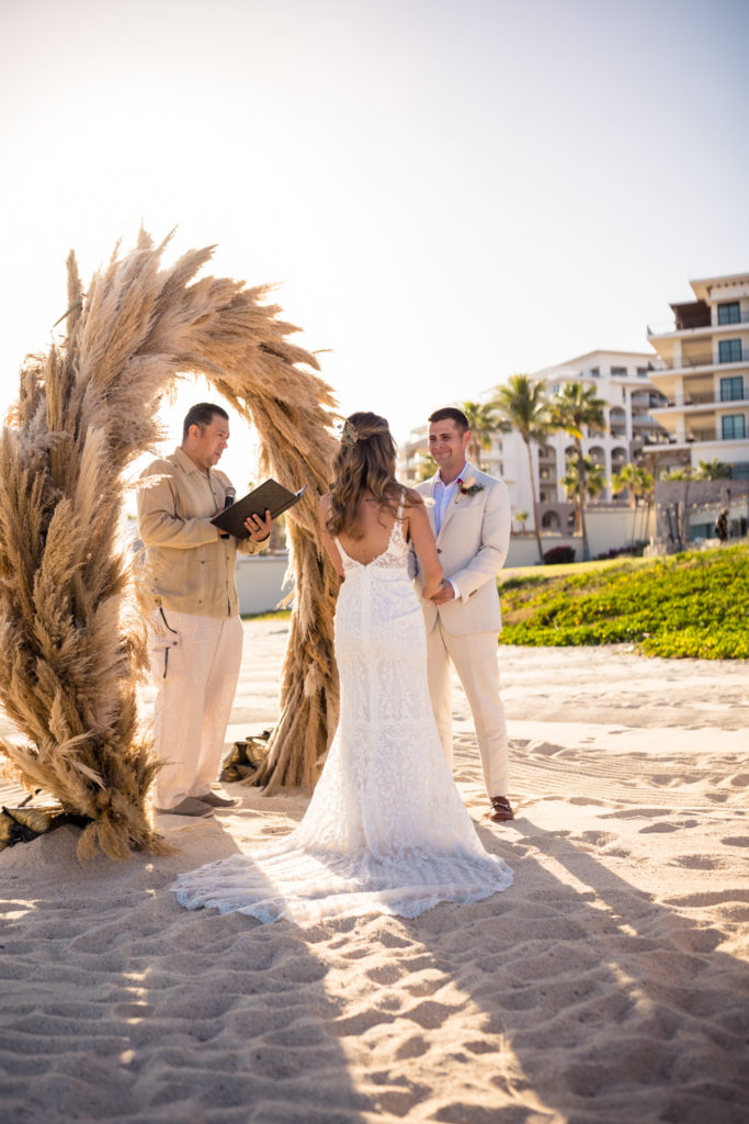 bride and groom holding hands during beach wedding