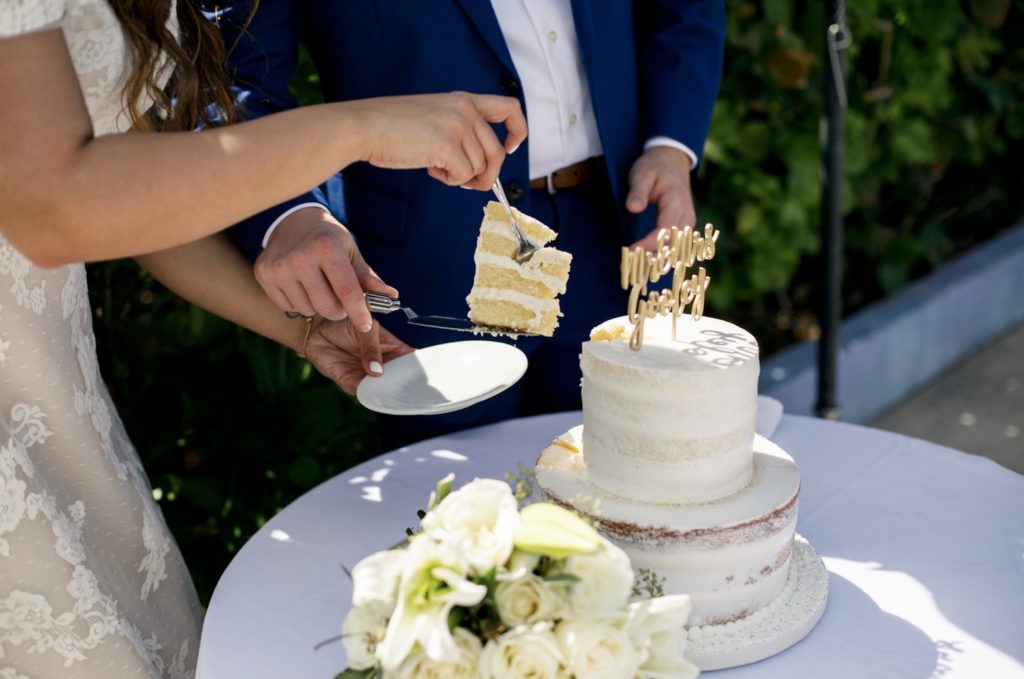 Close up of bride and groom cutting their cake during their elopement