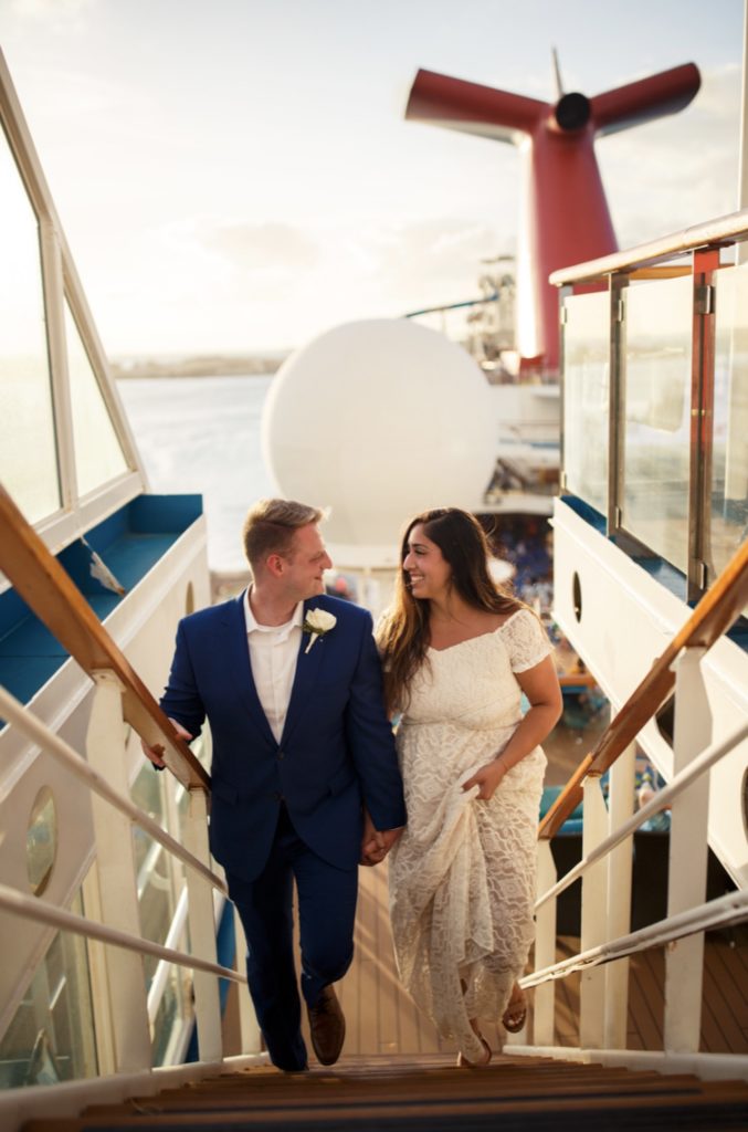 A bride and groom smile while walking on a cruise ship during their adventurous elopement photographed by Makayla McGarvey