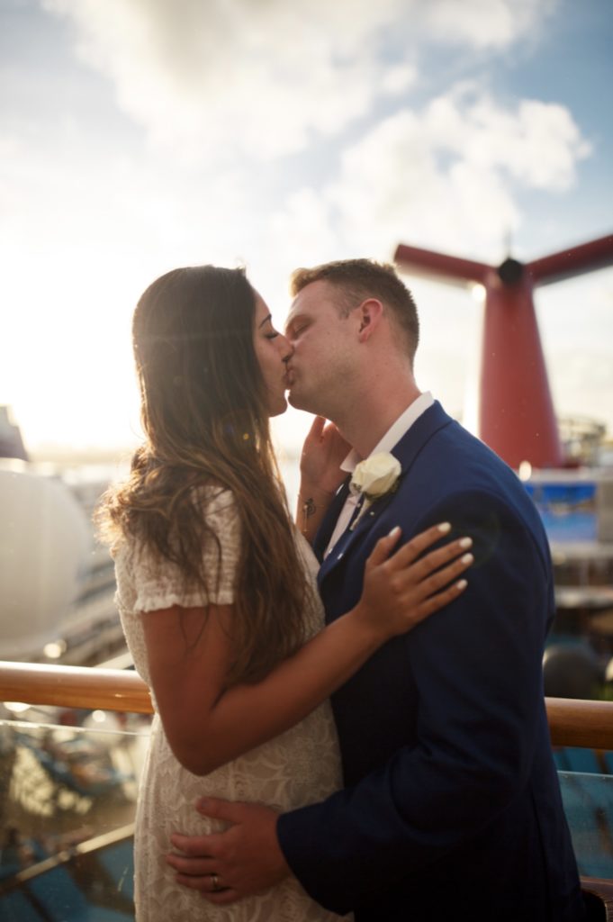 Bride and groom kiss while on a cruise ship as part of their elopement