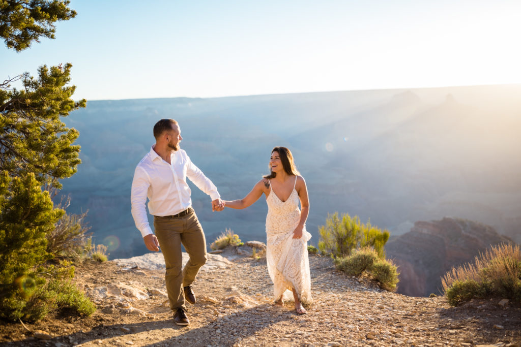 bride and groom walking by the edge of the grand canyon