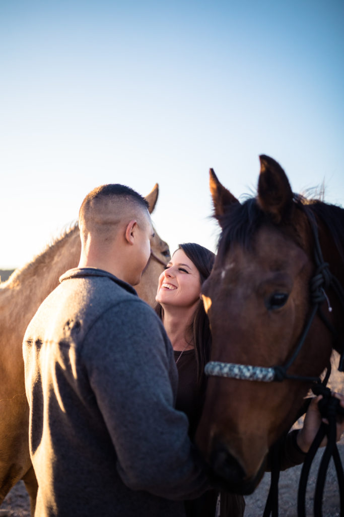 Couple look at each other with their pet horse beside them, shot by Makayla McGarvey Photography