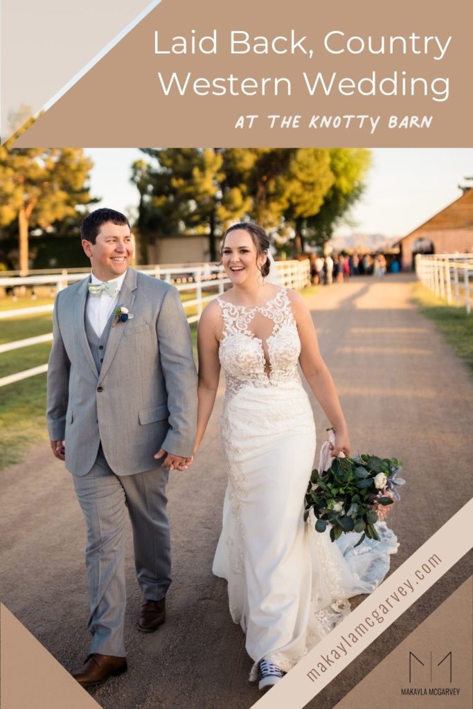 Groom and bride smiling as they stroll through the path at The Knotty Barn in Queen Creek, Arizona; image overlaid with text that reads Laid Back, Country Western Wedding at The Knotty Barn