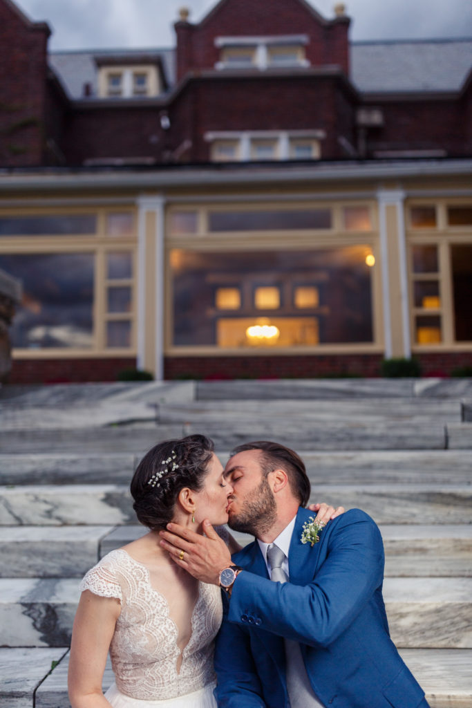 bride and groom kissing on marble steps