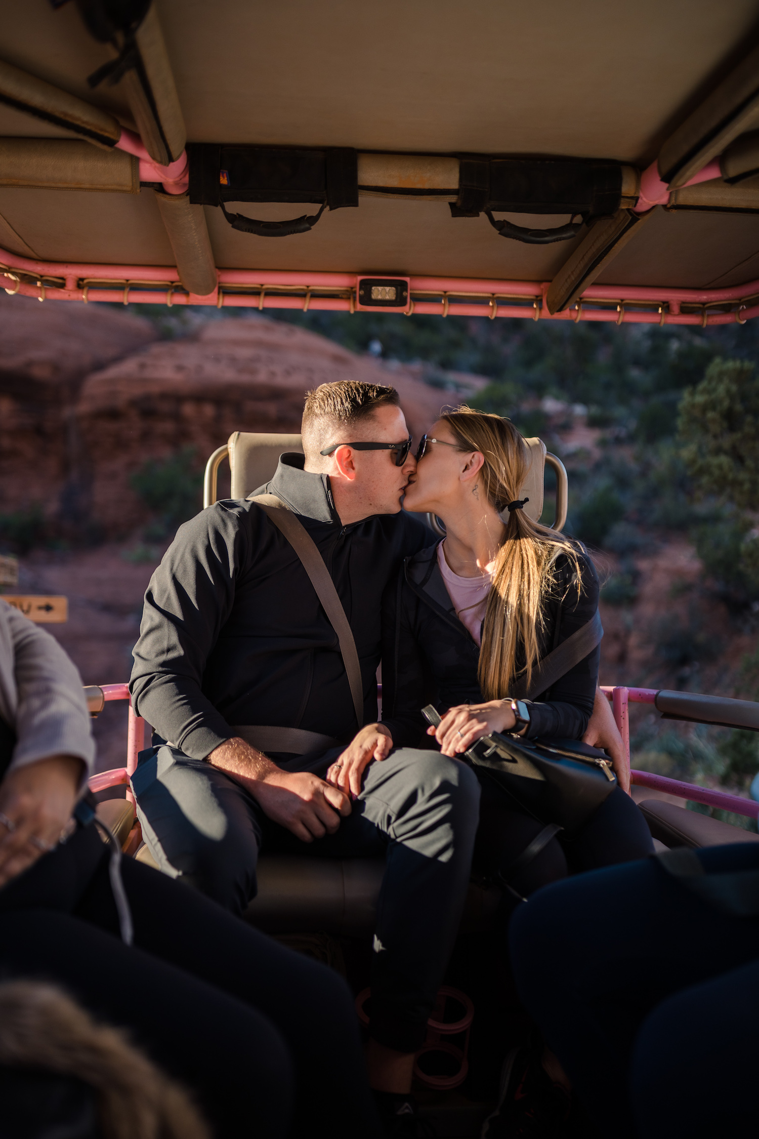 Couple sharing a kiss in the pink jeep during their Pink Jeep Tour, captured by Makayla MacGarvey Photography