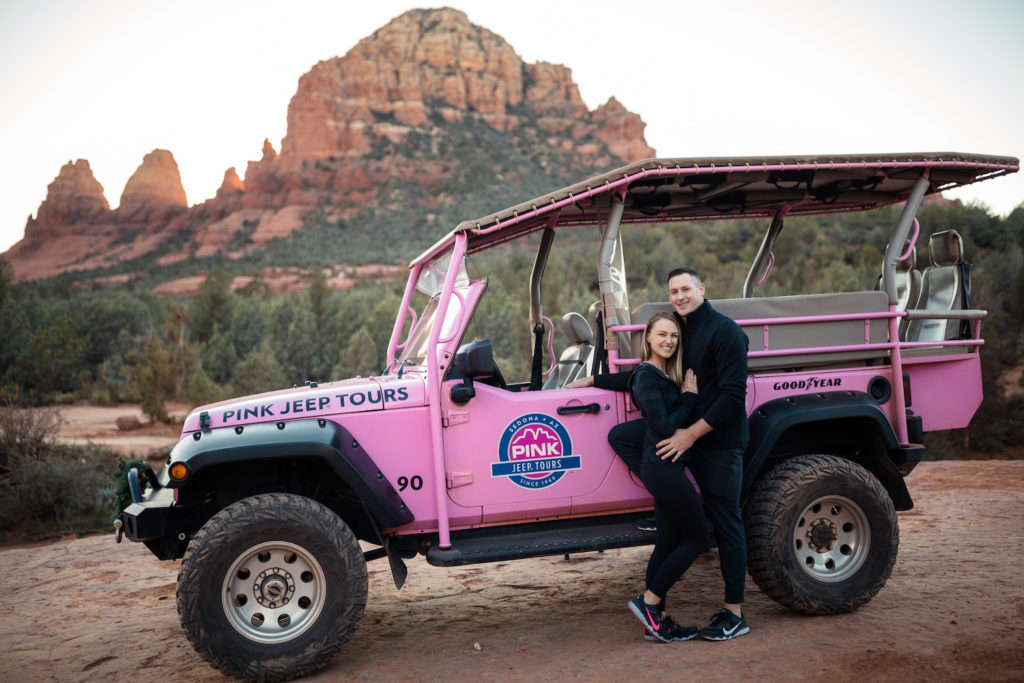 Newly engaged couple posing in front of the Pink Jeep during their proposal, shot by Makayla MacGarvey Photography