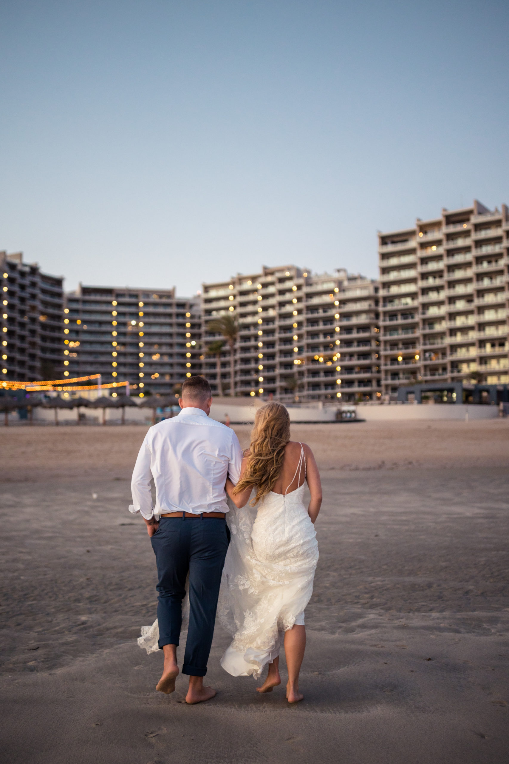 bride and groom walking towards las palomas resort