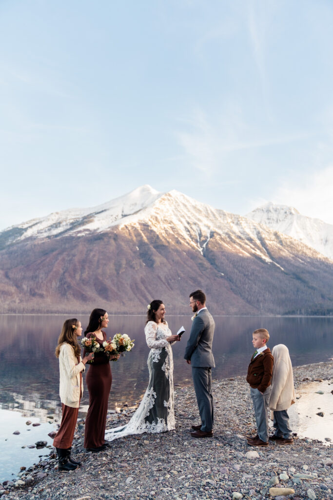 bride and groom getting married on lake mcdonald beach