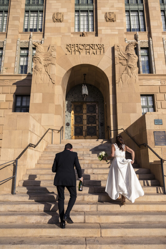 bride and groom walking up courthouse stairs