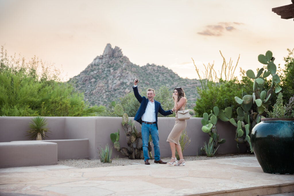 A proposal at the Scottsdale Four Seasons, one of the best places to propose in Phoenix. A man is pumping his fist after his partner said yes!