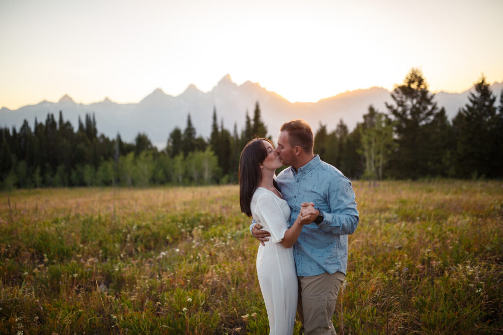 bride and groom kissing at sunset in front of the grand teton mountains