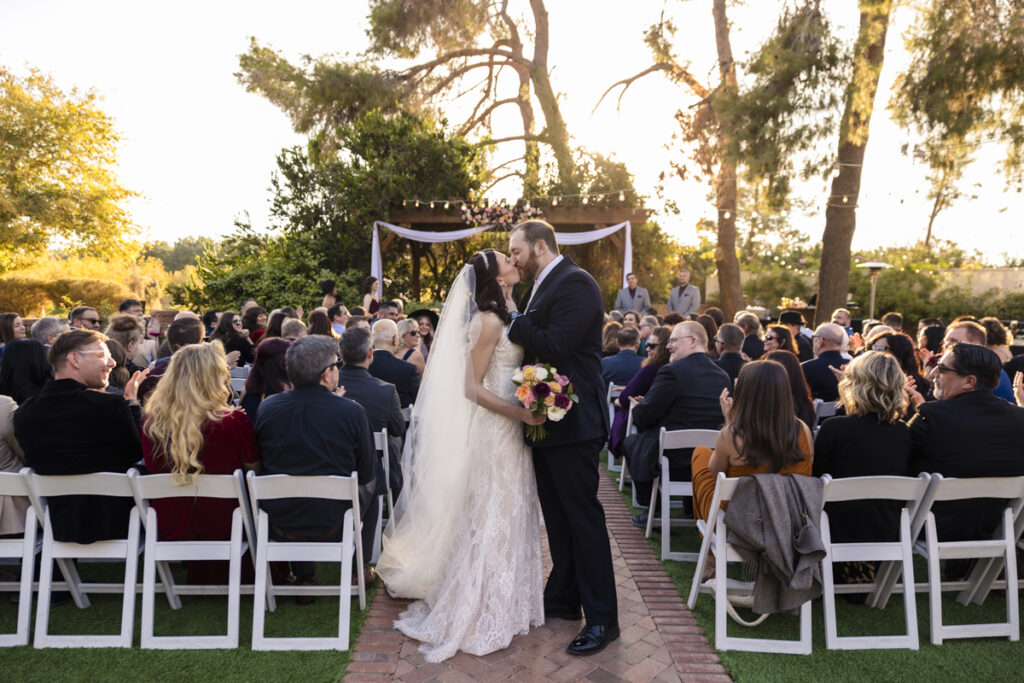 Bride and groom kissing at the end of ceremony aisle at schepf farms