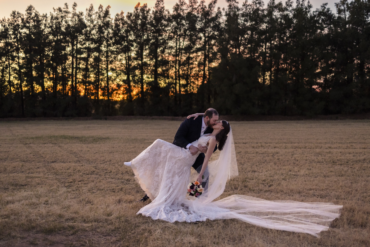 groom dipping bride in the meadows at schnepf farm