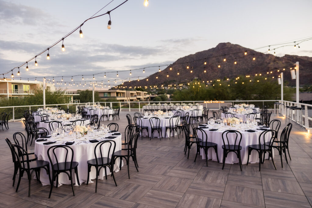 The Camelback Overlook at the Mountain Shadows wedding venue, with round tables set up on a balcony, Camelback Mountain in the backdrop.