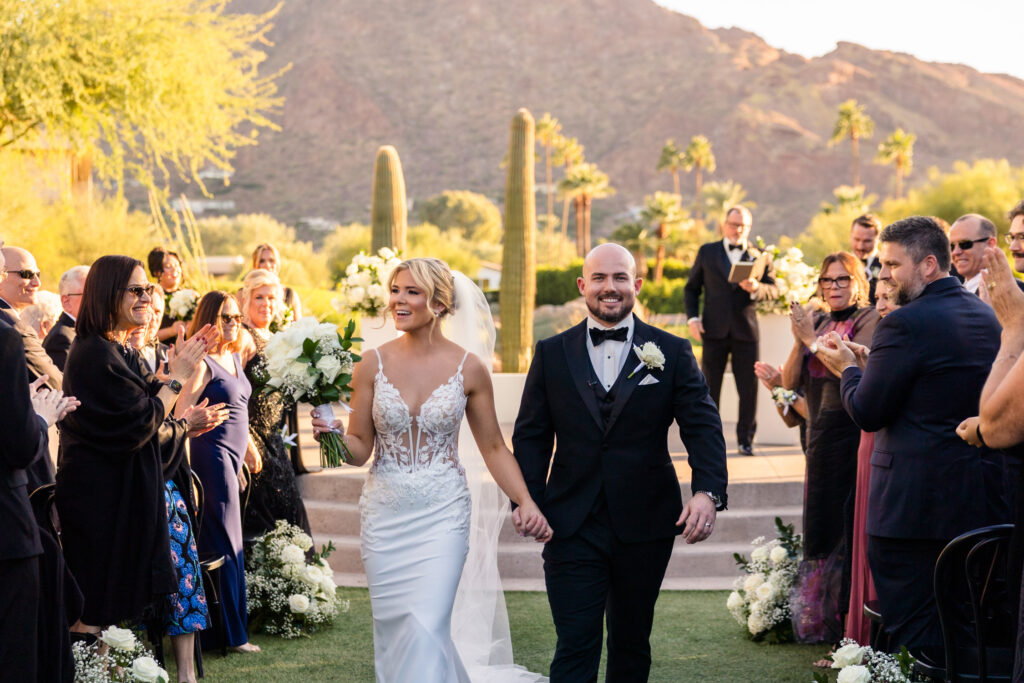 A couple walking back up the aisle after their wedding ceremony at the Mountain Shadows Resort.