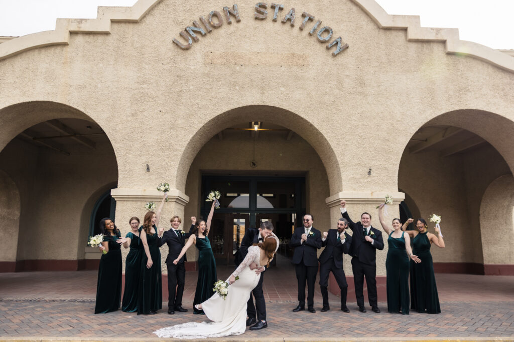 bride and groom with wedding party in front of union station