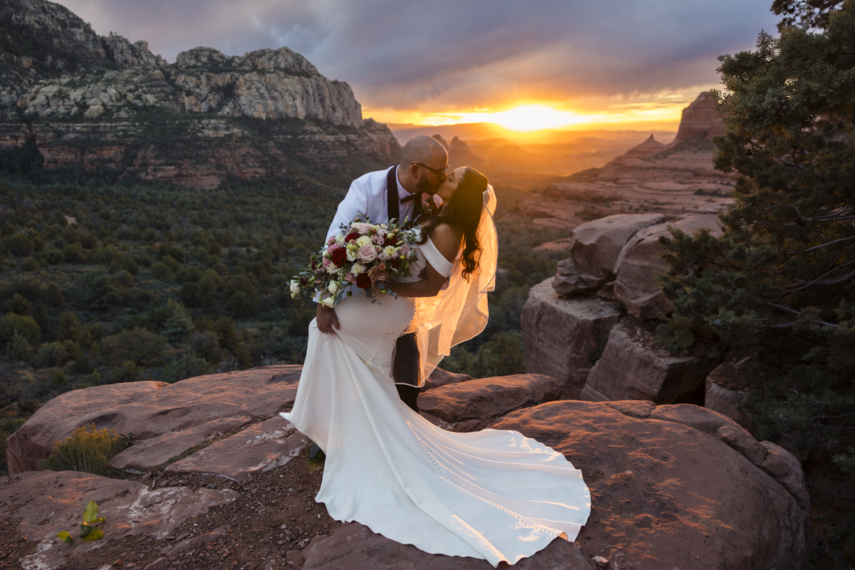 bride and groom kissing at merry go round rock