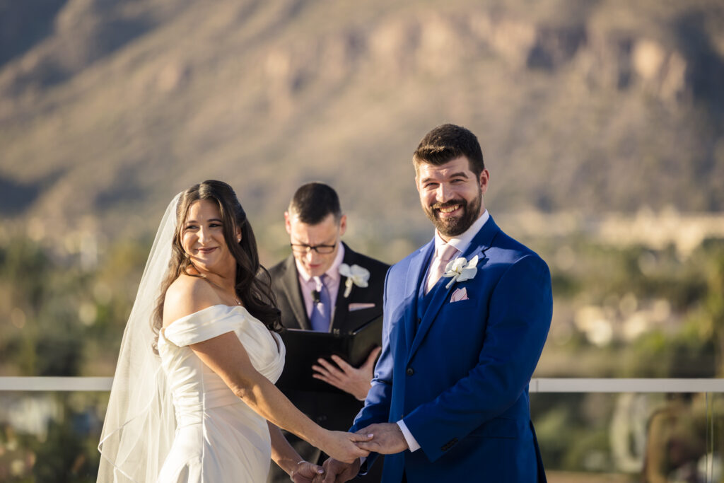 bride and groom looking at crowd during ceremony